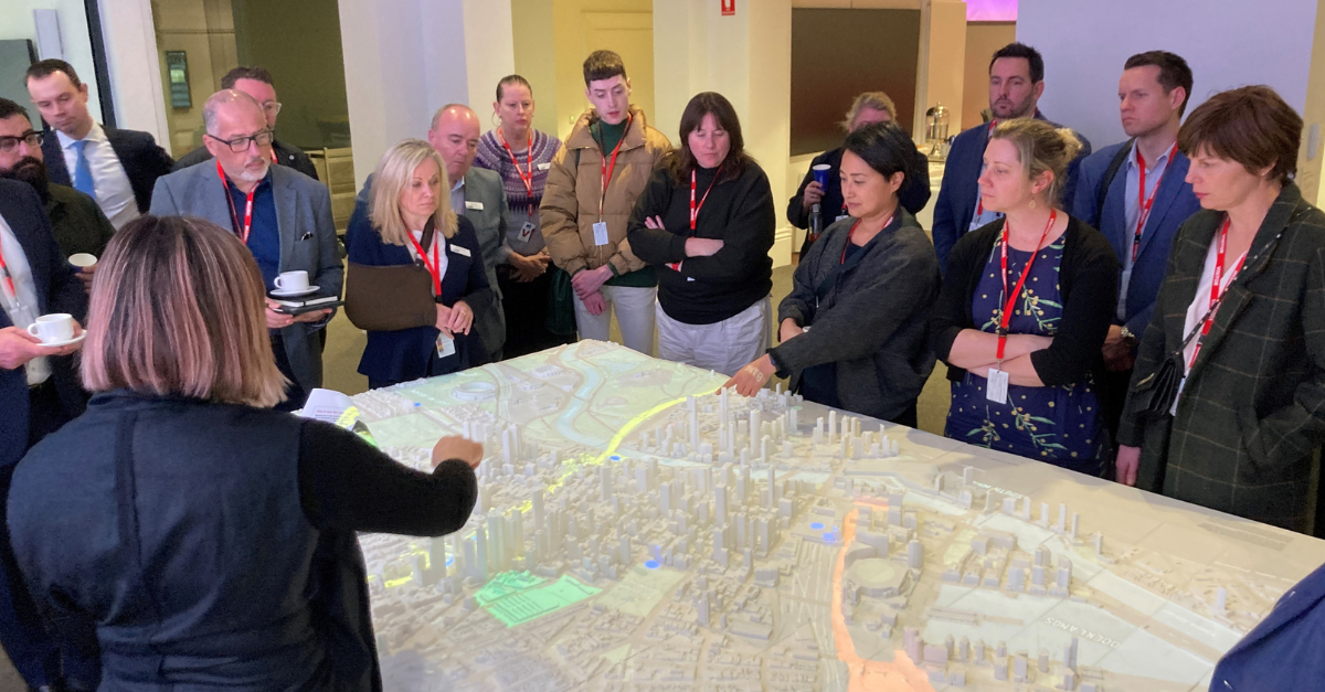 Group of people gathered around a 3D model of Melbourne's CBD
