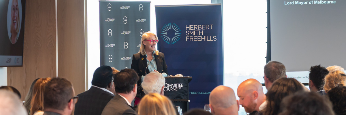 Sally Capp AO speaking at a lectern at event held at Committee for Melbourne event held at Herbert Smith Freehills